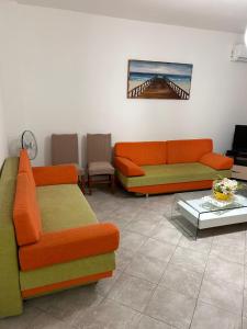 a living room with two couches and a table at Dona Elegant Beach Apartment in Durrës