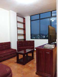 sala de estar con sofá y escritorio con TV en APART. ENTERO EN TENA - ECUADOR, 5 GUESTS, 2 ROOM, en Tena