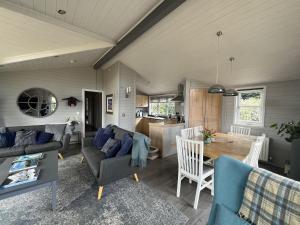 sala de estar con sofá y mesa en Holly Blue - Cosy wooden lodge Kippford en Dalbeattie