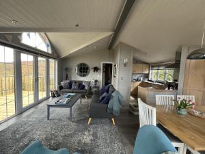 - un salon avec un canapé et une table dans l'établissement Holly Blue - Cosy wooden lodge Kippford, à Dalbeattie