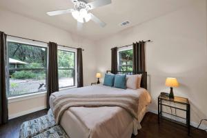 a bedroom with a bed with a ceiling fan and windows at The Inn at Shasta Lake in Lakehead
