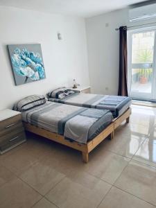 1 dormitorio con 2 camas y ventana en Holiday Apartment, Gzira, Malta, en Il-Gżira