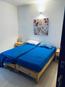 Un dormitorio con una cama azul con una pintura en la pared en Holiday Apartment, Gzira, Malta, en Il-Gżira