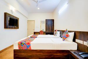 a bedroom with a large bed and a television at FabHotel GRK Comforts in Bangalore