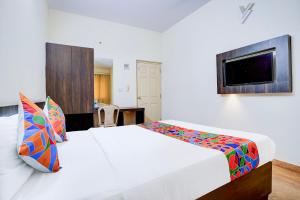 班加罗尔FabHotel GRK Comforts - Jayanagar的卧室里有一张白色的床和一台电视