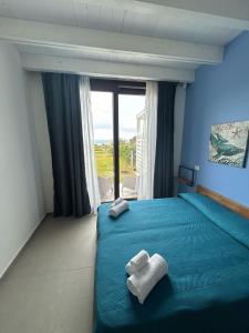 um quarto com uma cama azul com toalhas em Villa NATURE ZAGARA SCOPELLO ZINGARO em Castellammare del Golfo