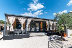 a house with white curtains in a yard at Mobile home Mia & Roko - Beach Porat, Drage in Drage