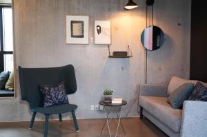 ein Wohnzimmer mit einem Sofa und einem Stuhl in der Unterkunft Hotel GUESTapart in Arhus