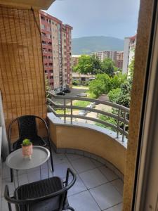 een balkon met 2 stoelen en een tafel en uitzicht bij Nika's Apartment in Skopje