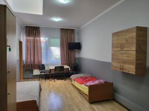 - une chambre avec un lit et une table avec des chaises dans l'établissement ALFA Noclegi, à Jędrzejów