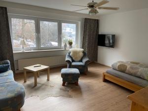 een woonkamer met een bank en een stoel bij Ferienwohnung Haseltal in Bad Orb
