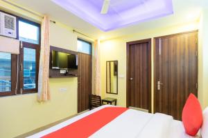 a bedroom with a bed and a tv on the wall at OYO Flagship Hotel R S Plaza in New Delhi