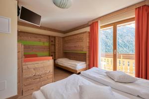 a bedroom with two beds and a large window at Berg Hotel Latemar Spitze in Vigo di Fassa