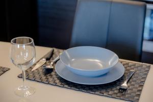 a bowl and a wine glass on a table at Solar Villa Apartmanok By BLTN in Siófok