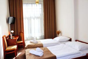 a hotel room with two beds and a window at Hotel Lothus in Wrocław