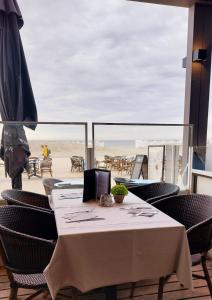a table and chairs with a view of the beach at Hotel Sandeshoved Zeedijk in Nieuwpoort