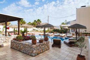 un resort con piscina attrezzata con sedie e ombrelloni di Villa Angira a Kamari