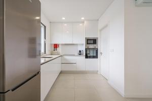 a white kitchen with white cabinets and appliances at Yama House 