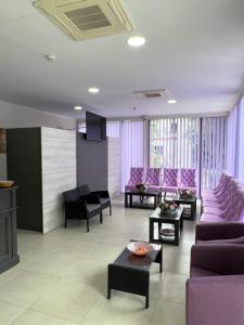 una sala de estar con muebles de color púrpura y sillas de color púrpura. en Hotel Violeta, en Jupiter