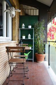 una mesa y sillas en un porche con plantas en Maurice PentHouse, en Roma