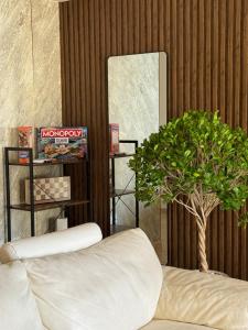 a living room with a white couch and a tree at SleepandGO in Dubai