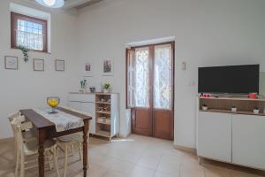a kitchen with a table and a television and a table and chairs at Noto Barocca - HolidayHome in Noto