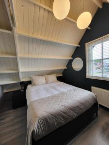 een slaapkamer met een groot bed en 2 verlichting bij Je B&B Giethoorn, incl fietsen! in Giethoorn
