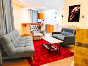un soggiorno con 2 divani e un tappeto rosso di TURACO INTERCOUNTY RESORT a Maragoli