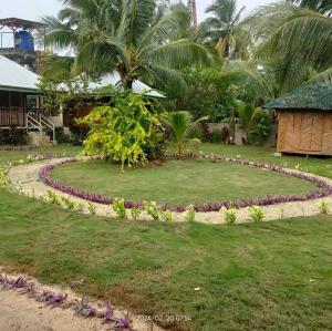 un jardin circulaire en face d'une maison dans l'établissement JMJ/GOD THE FATHER HOME STAY, à Caridad