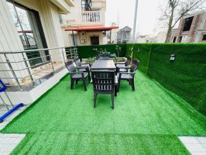 une table et des chaises sur une terrasse avec de l'herbe verte dans l'établissement AMPS Villa, à Wada 13 autres photos
