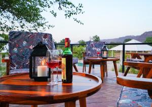 a table with two bottles of wine and a candle at Moustache Ranthambore Luxuria in Sawāi Mādhopur
