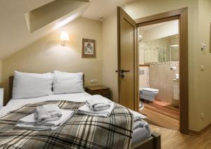 1 dormitorio con 1 cama con toallas en Penzión Kamea en Ždiar