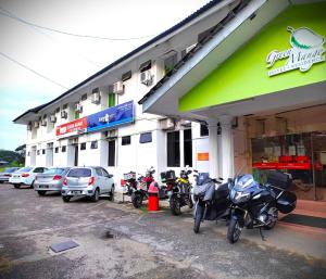 eine Gruppe von Motorrädern, die außerhalb eines Gebäudes geparkt sind in der Unterkunft Alia Express Green Mango, Kota Bharu in Kota Bharu