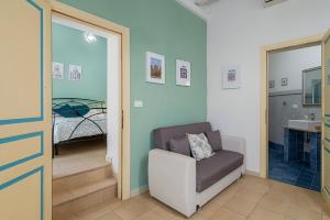 a living room with a chair and a bed at Noto Barocca - HolidayHome in Noto