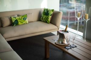 ein Wohnzimmer mit einem Sofa und einem Tisch mit Weingläsern in der Unterkunft Hotel SB Glow Sup in Barcelona