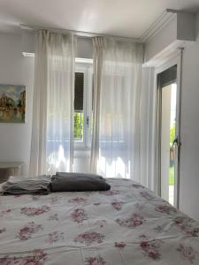 a bedroom with a bed and a large window at Lake side(5min)/fire place/garden/freeparking/45m2 in La Tour-de-Peilz
