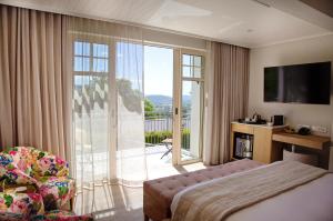 a hotel room with a bed and a sliding glass door at La Petite Ferme in Franschhoek