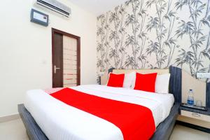 a bedroom with a large bed with red pillows at OYO Flagship Sangam Resort in Shāhpur