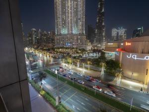 uma cidade à noite com trânsito numa rua movimentada em Luxurious Stylish Apartments Across Dubai Mall Burj Khalifa City Views no Dubai