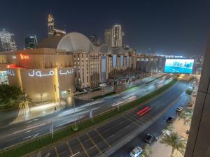 Una ciudad de noche con coches conduciendo por una calle en Luxurious Stylish Apartments Across Dubai Mall Burj Khalifa City Views en Dubái