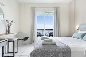 1 dormitorio con cama, escritorio y balcón en Sunset Premium Studio 7, en Agios Nikitas