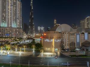 a large building in a city at night at Luxurious Stylish Apartments Across Dubai Mall Burj Khalifa City Views in Dubai