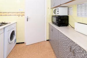 a kitchen with a microwave and a washer and dryer at La Farella 63 apartamento con terraza y vistas in Girona