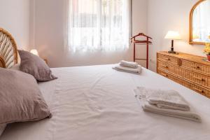 赫羅納的住宿－La Farella La Coma 61 apartamento zona tranquila，卧室配有带毛巾的大型白色床