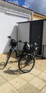 dwa rowery są zaparkowane obok budynku w obiekcie Maison proche centre, gare, aux Sables d'olonne w mieście Les Sables-dʼOlonne