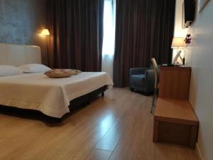 een hotelkamer met een bed en een stoel bij Relais Peucetia in Gravina in Puglia