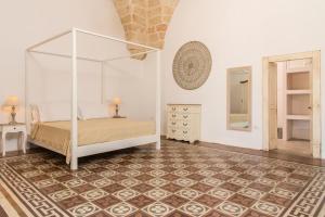 ein Schlafzimmer mit einem Himmelbett und einem Spiegel in der Unterkunft Di Lorenzi Albergo Diffuso in Felline