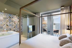 sypialnia z wanną i telewizorem w pokoju w obiekcie Hotel SB Glow Sup w Barcelonie