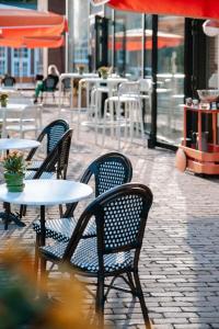 un grupo de sillas y mesas en un patio con mesas en Hotel Ryder I Den Bosch - Vught en Den Bosch