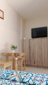 un salon avec une table et une télévision au mur dans l'établissement Topaz Bed & Breakfast Hotel, à San Jose